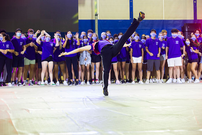 A student leaps in the air as he dances at Songfest