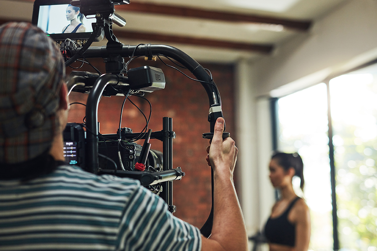 Personal with a camcorder getting ready to film a fitness video