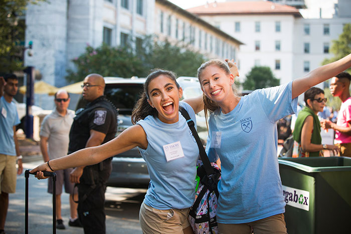 Two enthusiastic volunteers greet new students.