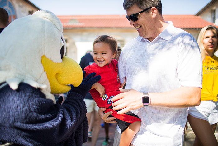 Emory's official mascot, Swoop, greets a new student's family members.
