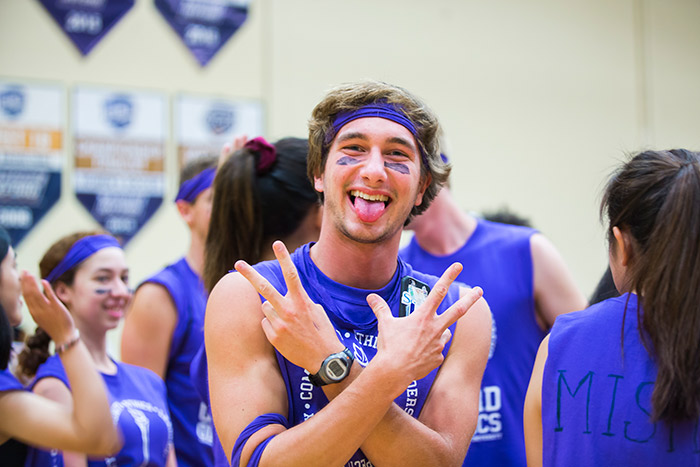 An Oxford College student wearing purple face paint poses for the camera.