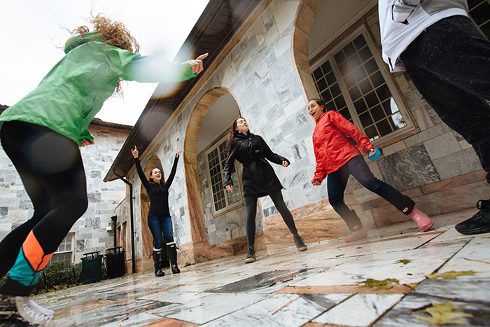 Students play in the rainy weather outside the dorms.