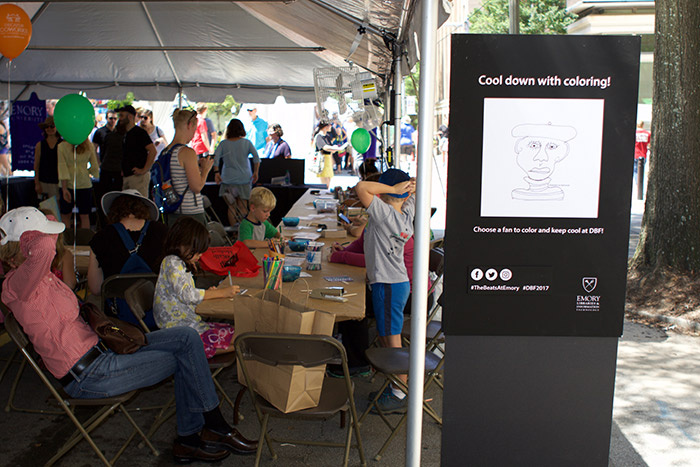 A group of children color at the Emory tent.