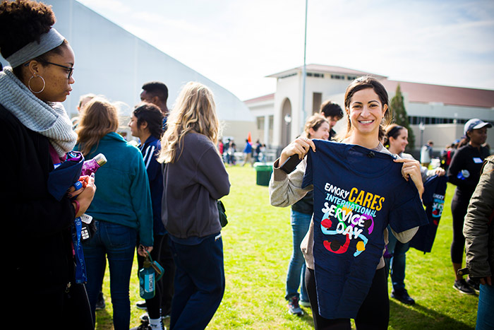A student holds up the t-shirt she received for participating in Emory Cares International Day of Service.