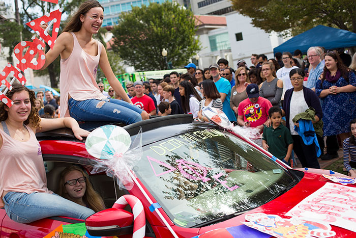 Students ride in convertibles at the 2017 homecoming parade.