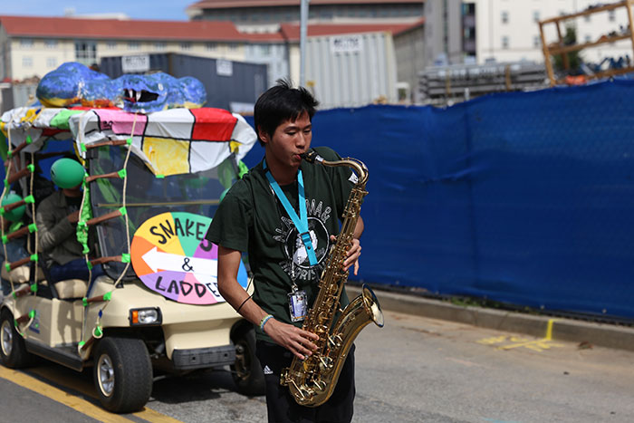 A student plays alto saxophone in the 2017 homecoming parade.