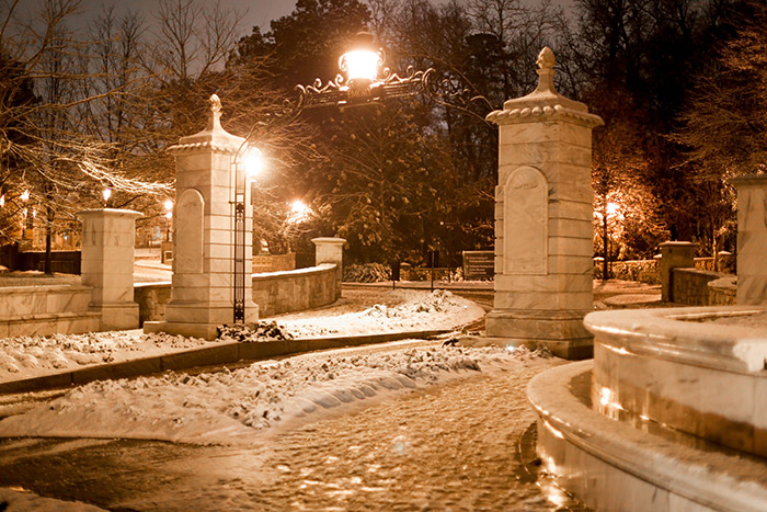 The iconic Emory gate is adorned with a few inches of snow Friday evening.