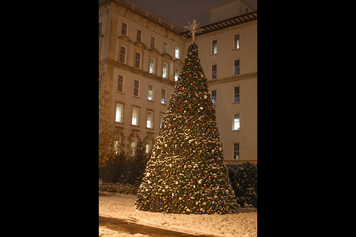 A tall Christmas tree in front of Emory University Hospital is surrounded by a few inches of snow.