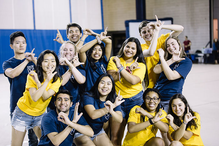 Students dressed in Emory colors pose before their Songfest performance