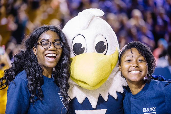 Two students pose with Swoop, Emory's athletics mascot