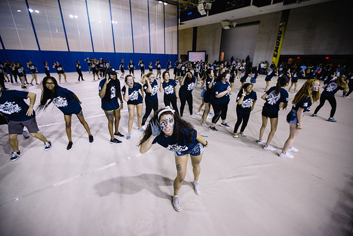 Students perform at Songfest, striking poses and making formations