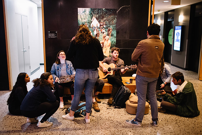 Emory students play guitar and chat in the Rose Library