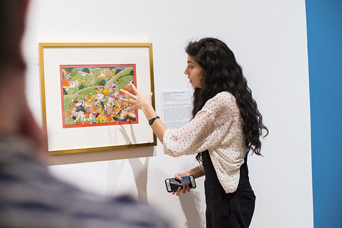 A student points at details in a work of art on display