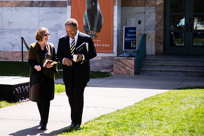 Robert M. Franklin and Emory President Claire E. Sterk laugh and chat as they walk at Conversations on the Quad