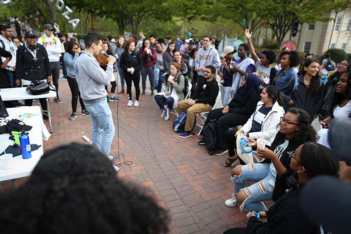 A student speaks to a large crowd at Dooley's Week