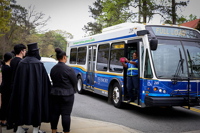 Dooley poses for a photo being taken by an Emory transit employee from the doorway of a campus bus