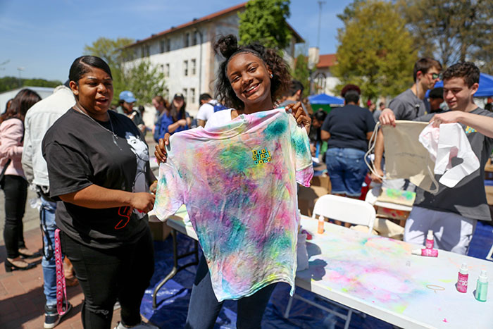 An Emory student holds up her tie-died t-shirts for Dooley's Week