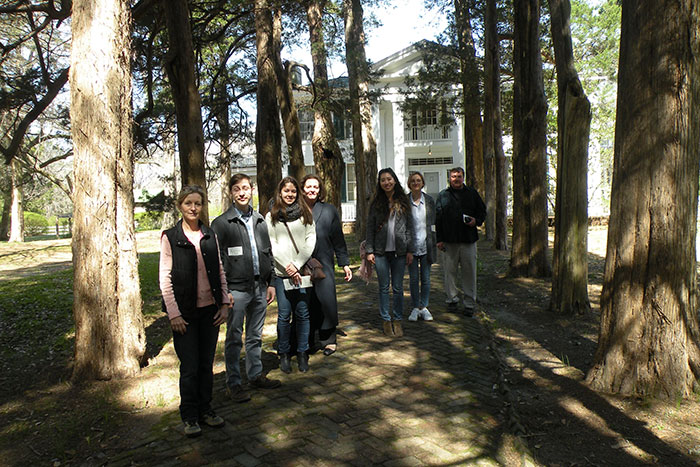 A group of Emory students stand in front of Rowan Oak