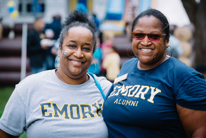 Two women wearing Emory t-shirts pose at the end of the Homecoming concert