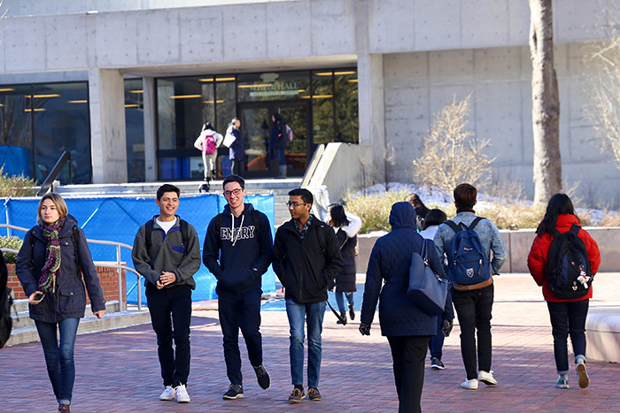 Several students talk and walk across campus together