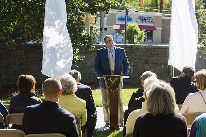 David Payne stands at a podium and addresses a small crowd at the PATH at Emory opening.
