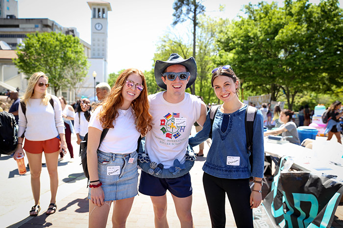 Three Emory students pose in denim clothing at Wonderful Wednesday at Asbury Circle.