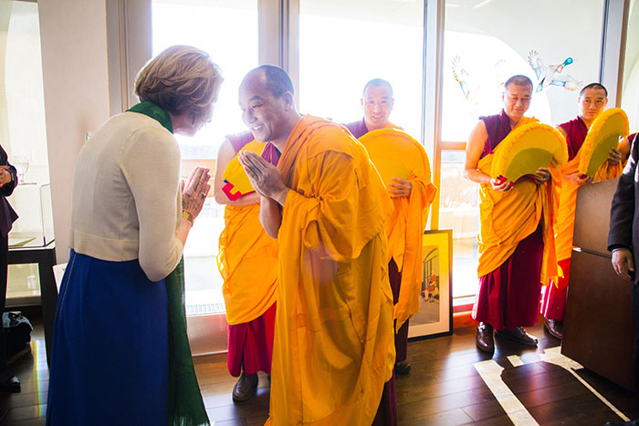 A Tibetan monk and Rosemary Magee exchange a bow.