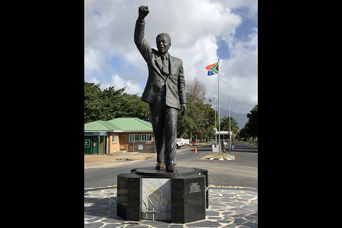 A statue of Nelson Mandela shows him holding a hand up in a fist