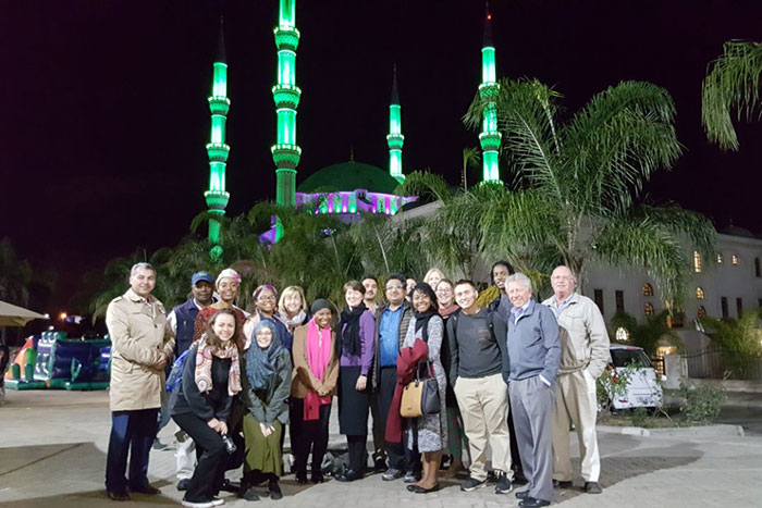 A dozen Journeys of Reconciliation participants stand outside of the Nizamiye Mosque and Islamic Complex in South Africa.