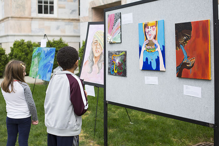 Two young visitors view artwork on display on the Quad.