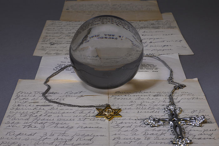 A crystal ball and a handwritten page of spells from the papers of Mamie Wade Avant