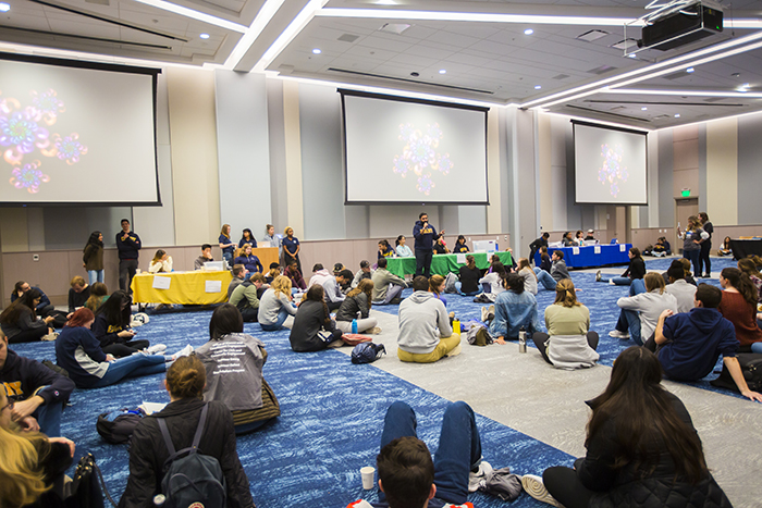 Students sit on a floor of the student center