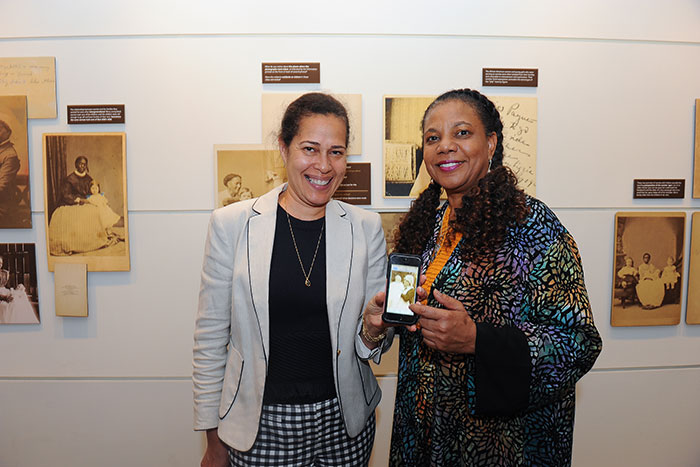 Barbara Coble (left), Emory Graduation Generation partnerships manager, shows Wallace-Sanders a photo of her great-great-grand-aunt, who was a nanny for a white family.