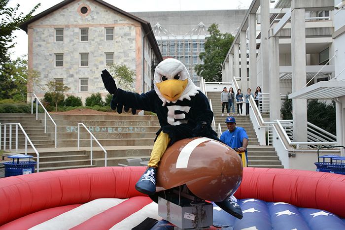 Emory's mascot, Swoop, rides a football-shaped mechanical bull