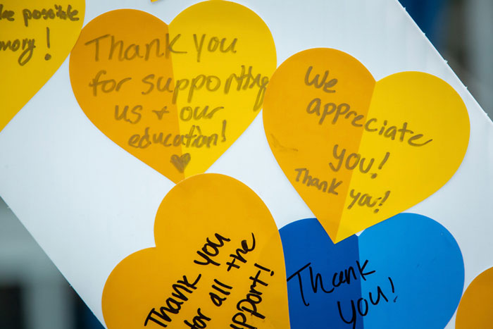 A close-up of thank you notes written on gold and blue hearts