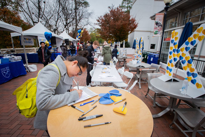 Students outside of Cox Hall write thank you notes to donors