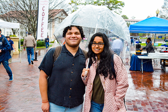 Two students share an umbrella as they walk through the rain in Asbury Circle