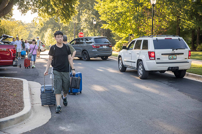 A student pulls suitcases on Move-In Day