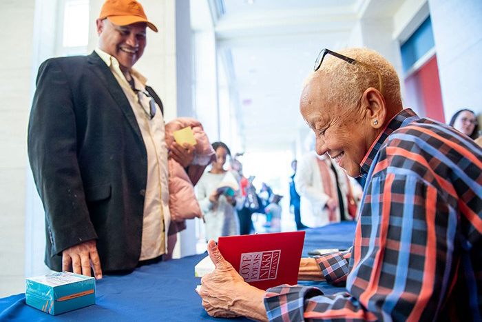 Nikki Giovanni signs a book for a fan