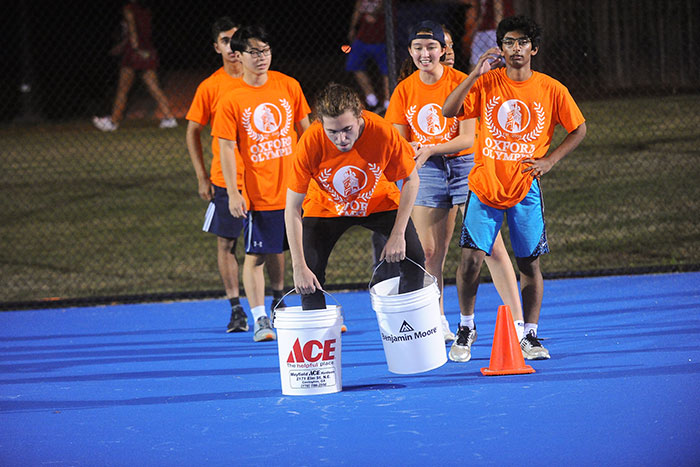 Students in orange t-shirts compete in the Oxford Olympics