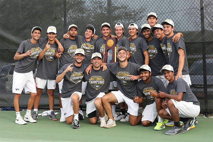 Men's tennis players pose with trophy
