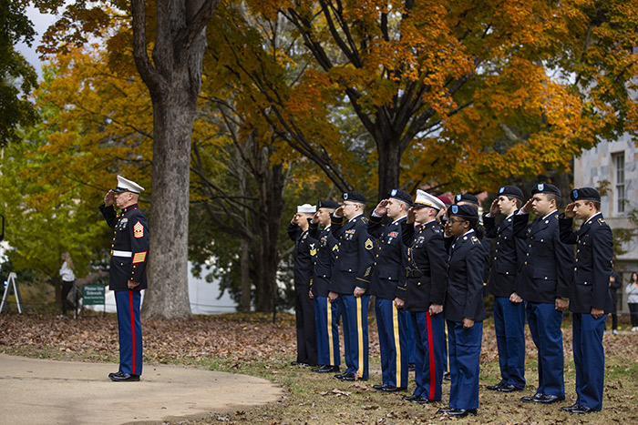 Members of the U.S. military dressed in uniform salute the flag