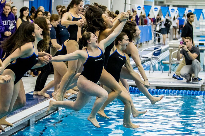women swimmers jump into the pool in celebration 