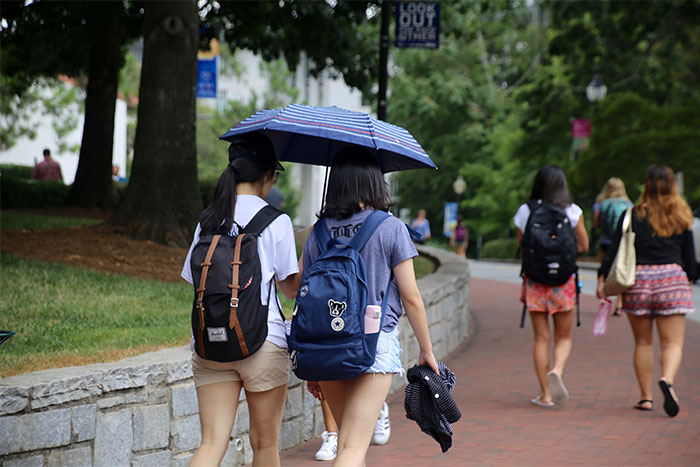 two people walking with an umbrella 