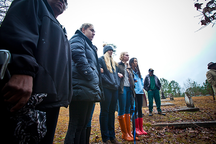Students linked arms as they stood in the light rain watching as Dorothy Nixon Williams saw her father's grave. 