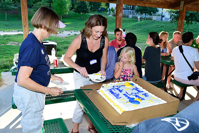Barb Ribner (left), Bruce Ribner's wife, and Sonia Bell, program coordinator for the SCDU, cut and serve the "thank you" cake.