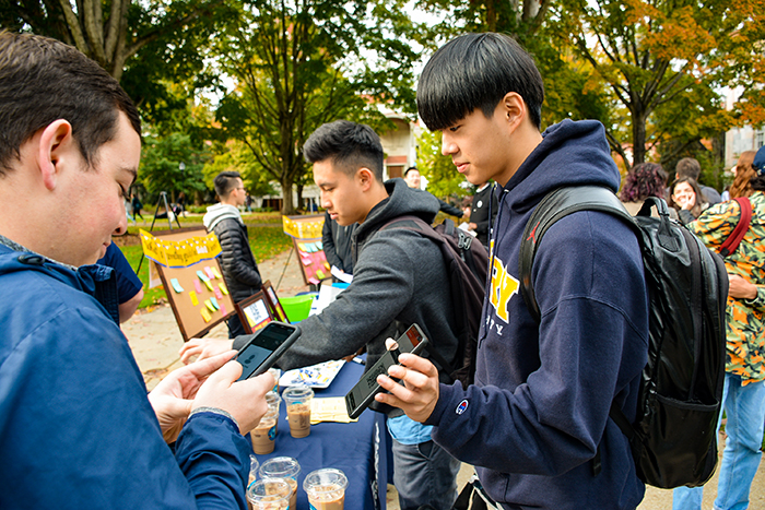 Students interact with people at a booth