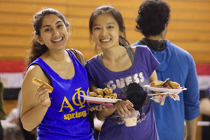 Two females with plates of food in their hand
