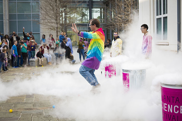 Demonstrators lead the "Physics Live!" event, and cloudy smoke comes out of trash cans in a controlled manner
