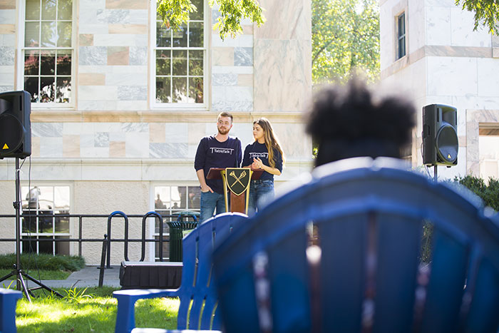 Two young speakers address the crowd from a podium at Conversations for the Quad